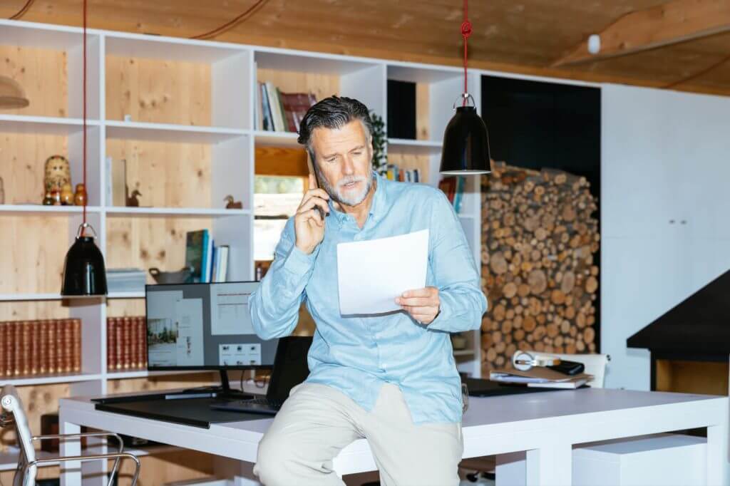 Elderly Cool Man Taking a Phone Call in his Office