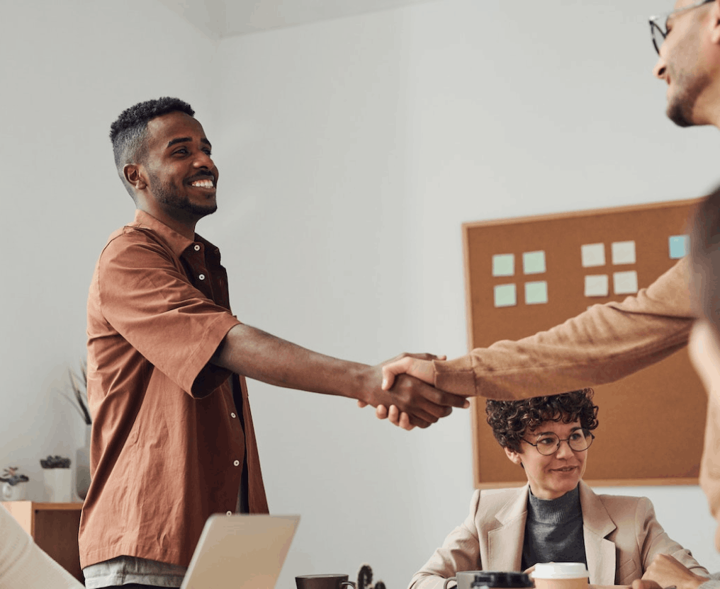 two partners looking at eachother giving a handshake